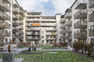 Innergården på SKB-kvarteret Ananasen, med träd, utemöbler och konst.