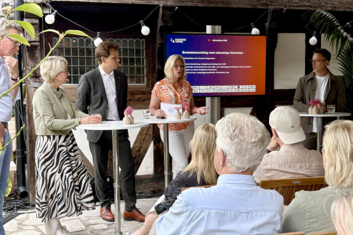 Fem personer i ett scensamtal framför en sittande publik.