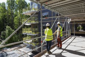 Två projektledare närstuderar ett pågående bygge av ett SKB-kvarter
