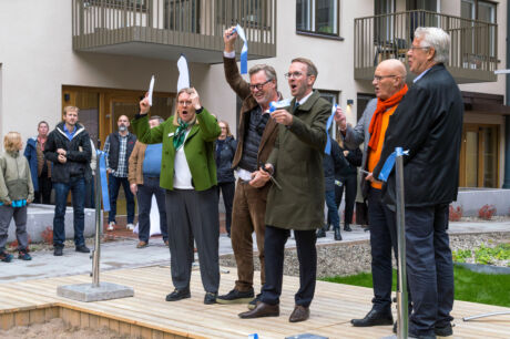Fem personer har just klippt ett invigningsband på innergården till kvarteret Ananasen med publik runt omkring.