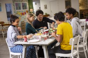 Glada tonåringar sitter vid ett middagsbord