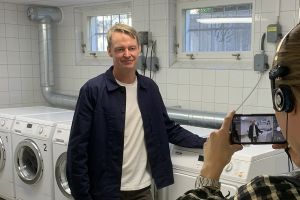 SKBs fastighetsutvecklingschef Johan Jarding blir intervjuad för P4 Stockholm i en tvättstuga i SKB-kvarteret Dyvinge