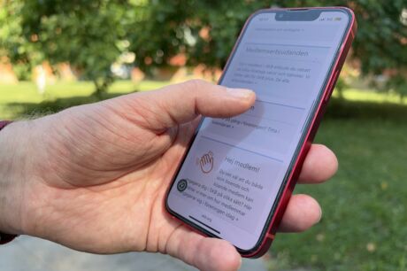 Hand med mobiltelefon som visar Mina sidor.
