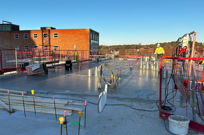 Ett SKB-hus under byggnation i Gustavsberg. En byggarbetare syns i bakgrunden.