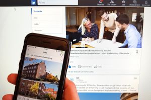 Mobiltelefon som visar SKBs instagramkonto framför en datorskärm som visar SKBs LinkedIn-konto
